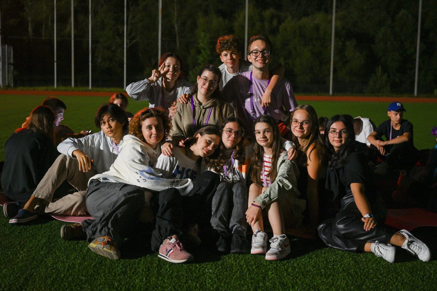 Friends from the summer school sitting together on the field at night
