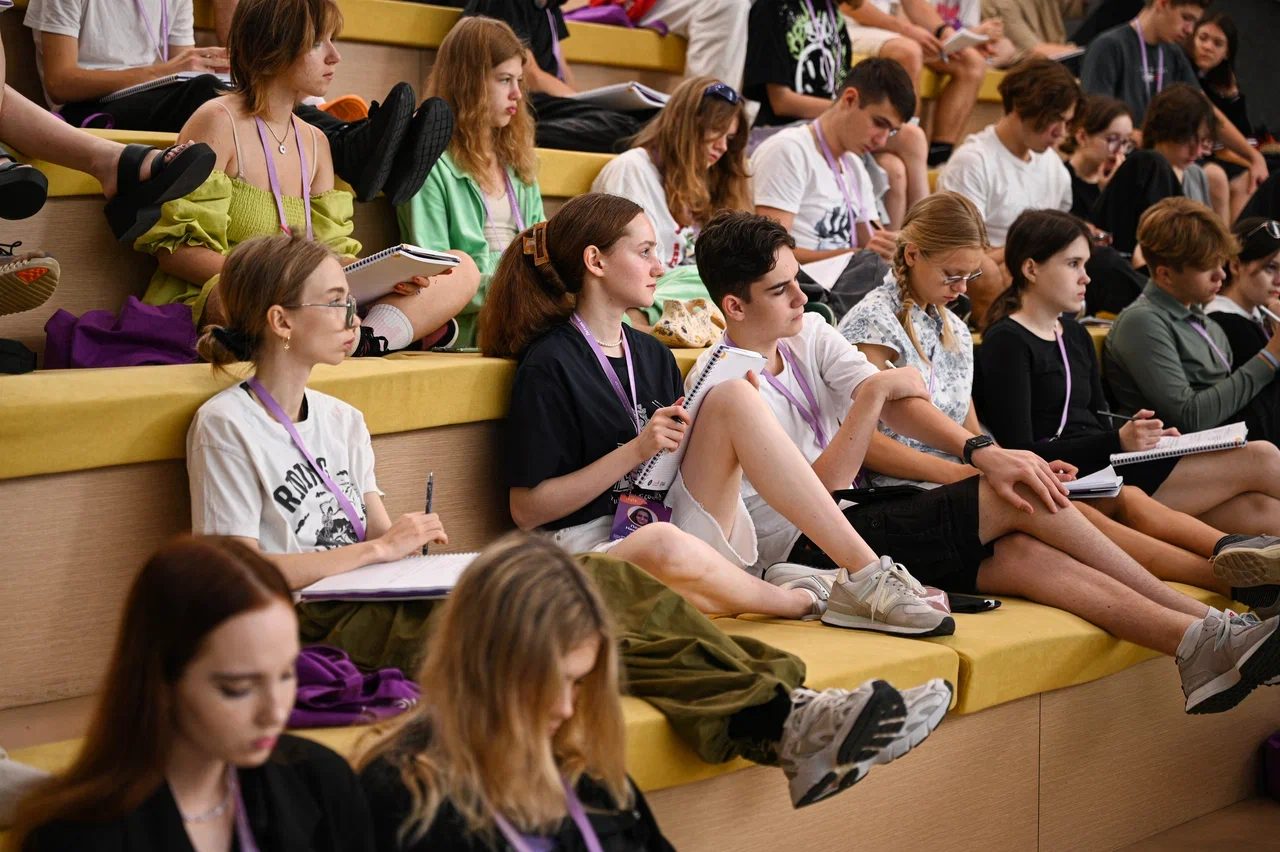 Participants taking notes on the amphitheatre steps during a lecture