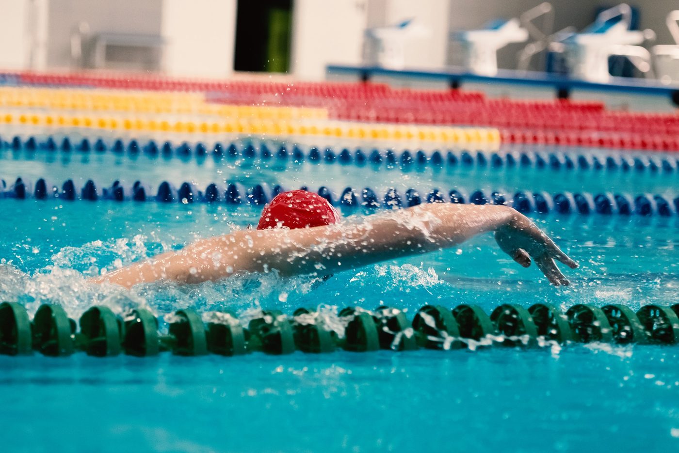 Aleksei swimming front crawl in a red cap